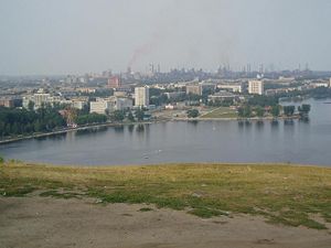 Нижний Тагил с Лисьей горы: заводской пруд, современный центр города, а на заднем плане — трубы и дымы НТМК